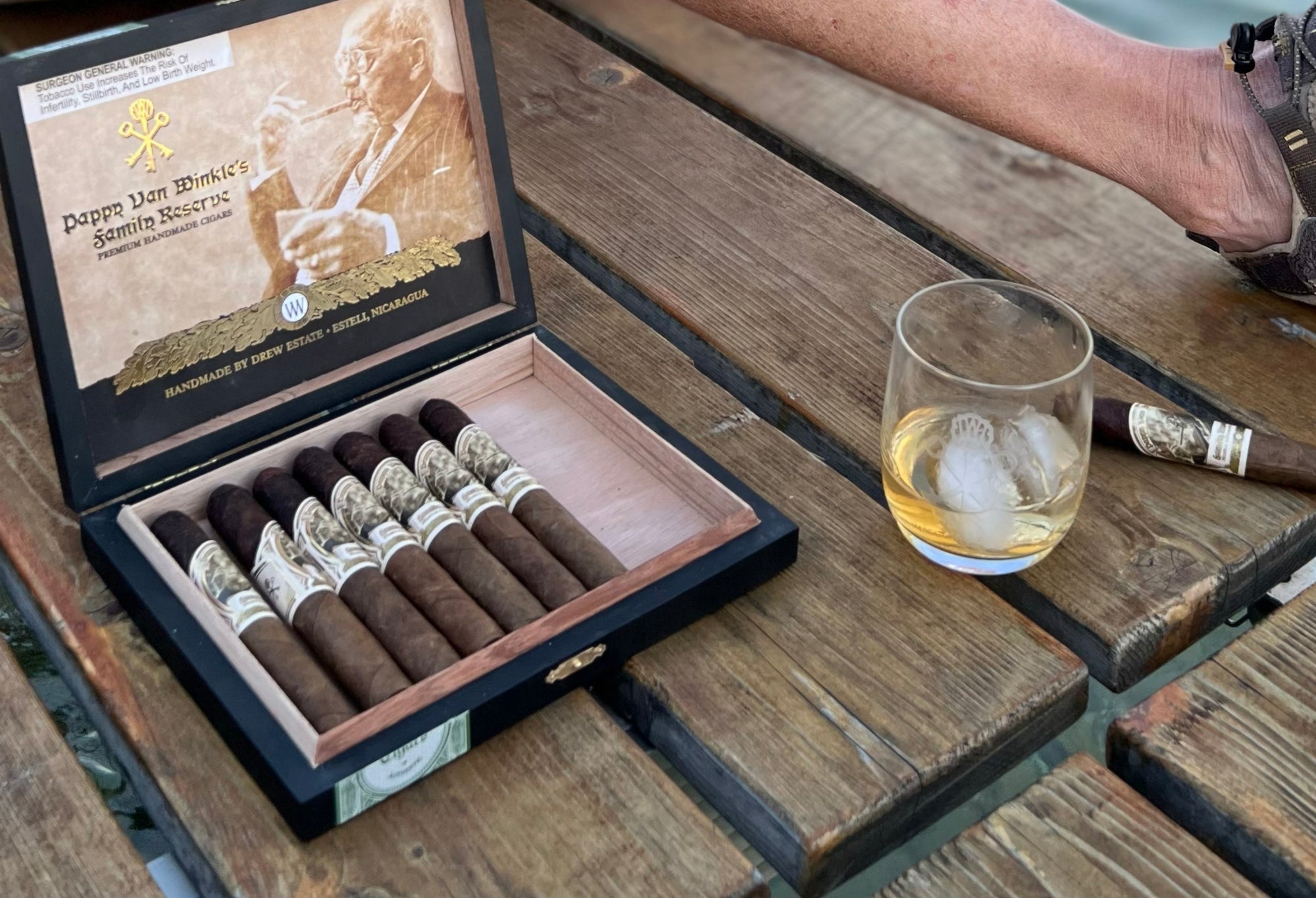 Cigars on a doc with a glass