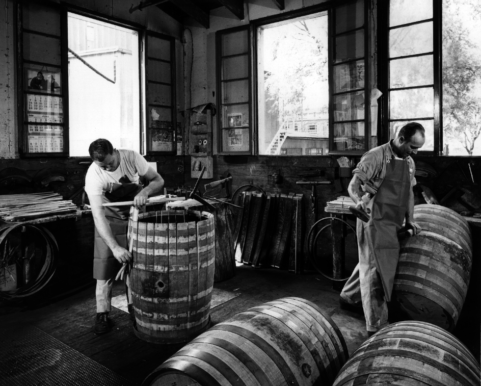 Black-and-white photo of coopers building bourbon barrels in a cooperage